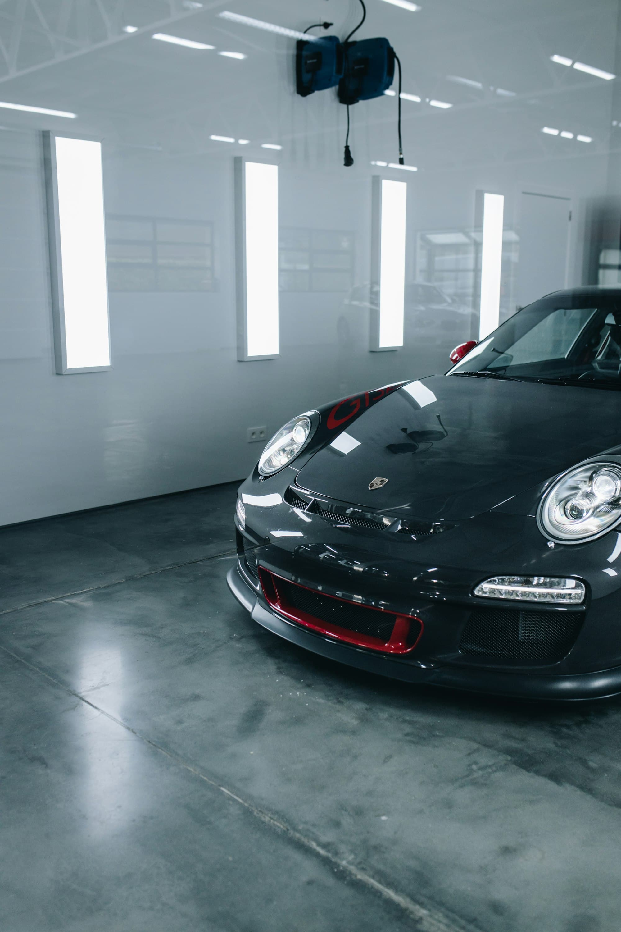 Black Porsche in a professional studio with reflections from detailing lights